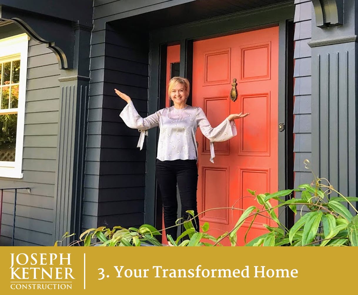 A happy female home owner standing in front of a red front door