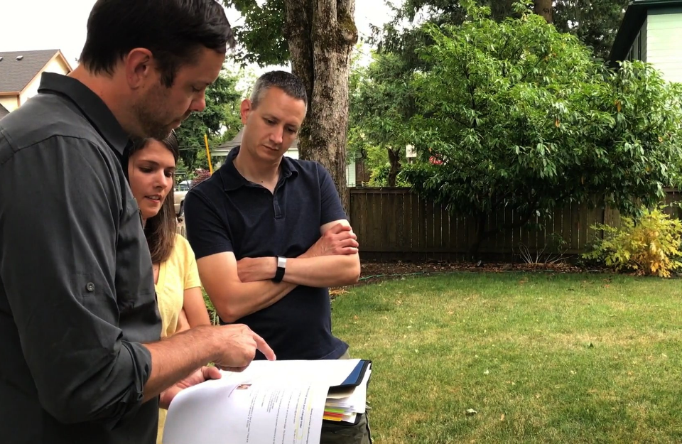 Three people planning renovations in a yard to illustrate how to increase home value by $50k.